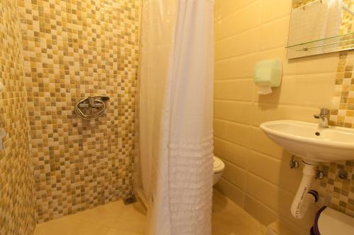 een badkamer met een douche en een wastafel bij Apartments Feniks in Ulcinj