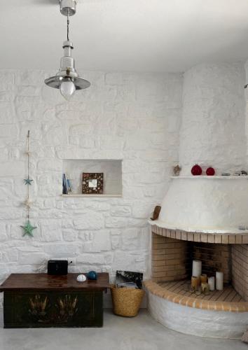 a living room with a brick fireplace and a ceiling at LA MAISON D'HELENE in Naousa