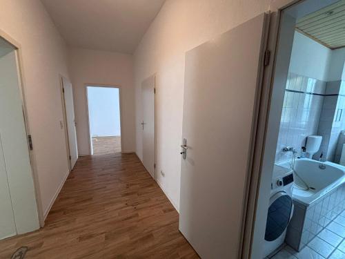 a hallway of a bathroom with a sink and a mirror at Spacious Flat with 3 bedooms for 5-8 guests in Zeitz