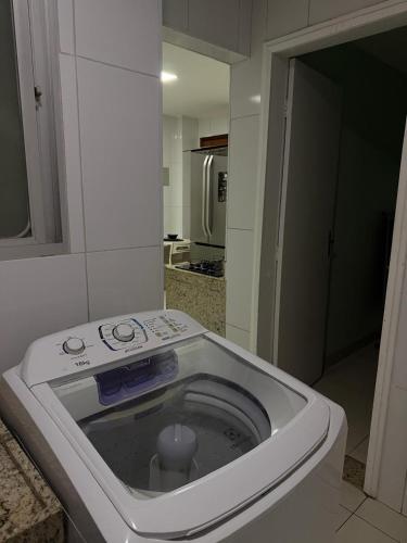 a kitchen with a washing machine in a room at Ed forte da Praia in Guarapari