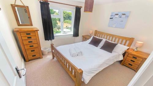 a bedroom with a bed with two shoes on it at Cloudbreak Hot Tub Log Burner Dogs Welcome in Braunton