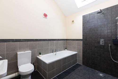 a bathroom with a toilet and a bath tub at Blackberry Barn in Wotton-under-Edge