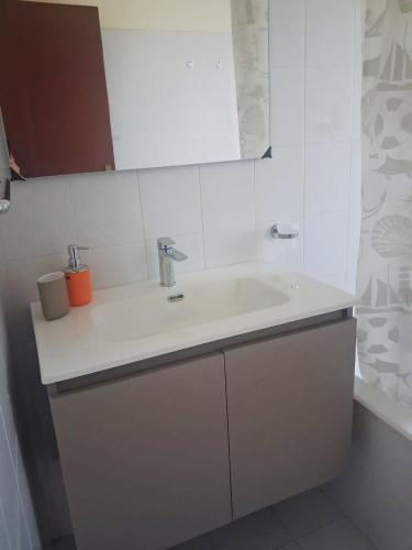 a white bathroom with a sink and a tub at The Citrus Balcony in Trappitello