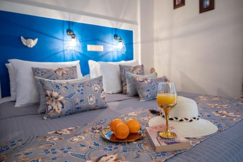 a bed with a tray of oranges and a glass of wine at vranas hotel in Skala Sotiros