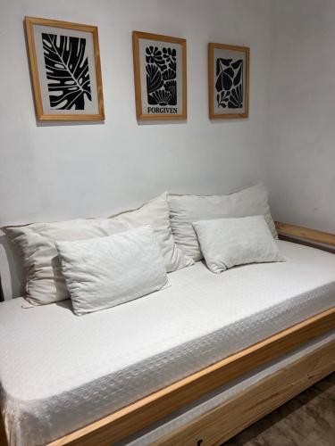 a bed with white sheets and pillows in a room at Quinta los Lopez in Azul
