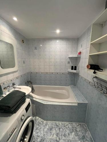 a white bathroom with a tub and a sink at BardiHome in Bardejov
