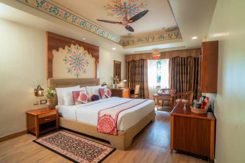a bedroom with a large bed with a ceiling at Chokhi Dhani The Palace Hotel in Jaisalmer