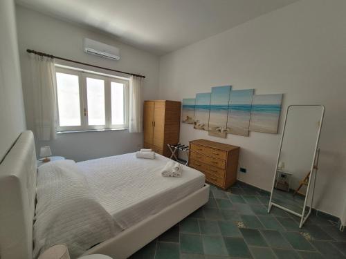 a bedroom with a large bed and a mirror at Casa Cachepot - Sweet Silvana in Ischia