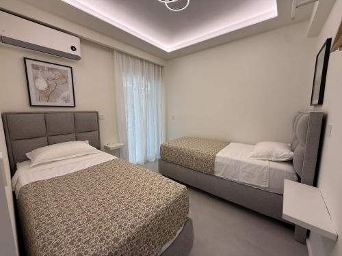 a bedroom with two beds and a tv in it at Loutraki Sea Breeze Sunset Apt in Loutraki