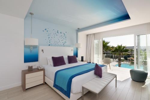 a bedroom with a king sized bed and a balcony at The View Bouznika in Bouznika