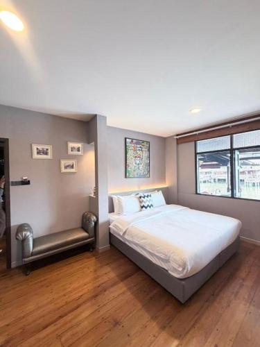 a bedroom with a large bed and a window at Little Bangkoknoi in Ban Bang Si Thong