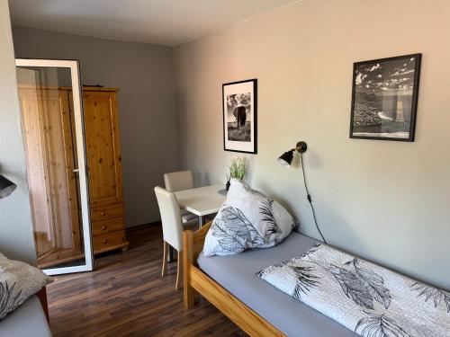 a bedroom with a bed and a table with a desk at Gästehaus Kerle in Dossenheim