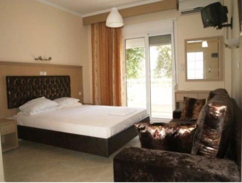 a bedroom with a bed and a window and a couch at Sun Studios Pieria in Paralía Skotínis