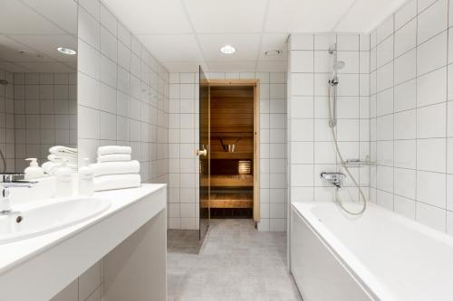 a white bathroom with a tub and a sink at Original Sokos Hotel Viru in Tallinn