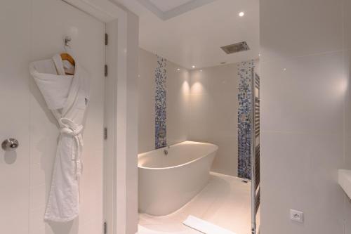 a white bathroom with a tub and a shower at The View Bouznika in Bouznika
