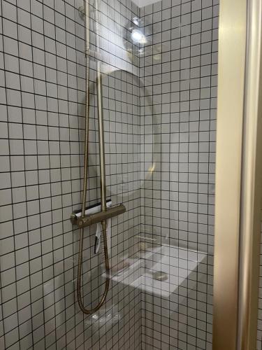 a shower in a bathroom with white tile at Cozy apartment in Moliets-et-Maa