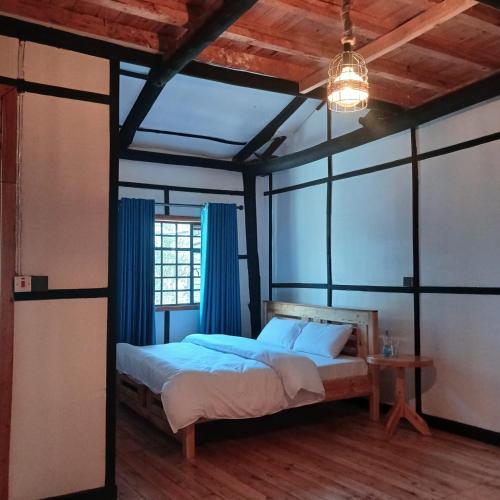 a bedroom with a bed with blue curtains at EarthShip Log Cabin, Timau in Nanyuki
