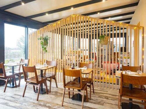 a restaurant with tables and chairs in a room at greet Hotel Nancy Sud in Houdemont