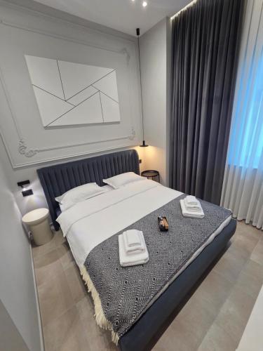 a bedroom with a bed with two towels on it at Motty Residence in Vicovu de Sus