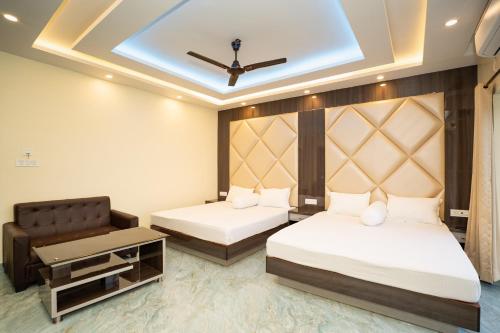 a hotel room with two beds and a chair at Mahabhoj Hotel & Restaurant in Mandarmoni