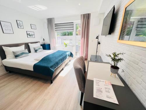 a hotel room with a bed and a desk with a computer at SOFI-LIVING-APARTMENTS in Hannover
