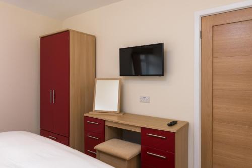 a bedroom with a desk and a tv on the wall at North Parade Avenue in Oxford