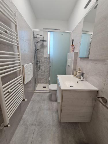 a bathroom with a sink and a toilet and a shower at Casa Timavo in Ronchi dei Legionari