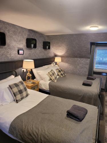 a hotel room with two beds and a window at BELLFIELD HOUSE in Broadford