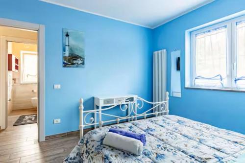 a blue bedroom with a bed and a window at Domus Bolsena in Bolsena