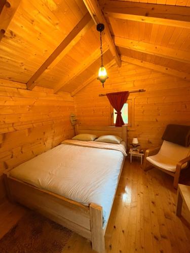 a bedroom with a bed in a wooden cabin at EtnoPetra in Mojkovac