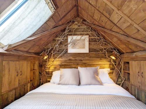 a bedroom with a bed in a wooden attic at Brooks Farmhouse - Pulborough in Pulborough