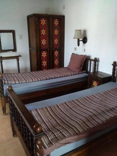 パナギュリシテにあるBonbon Guest Houseのベッド2台が隣同士に設置された部屋です。