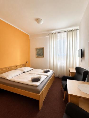 a hotel room with a bed and two chairs at hotel Sádek in Díly