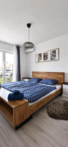 a bedroom with a large bed with a blue comforter at Apartman Promaja in Široki Brijeg