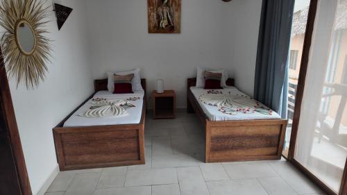 two twin beds in a room with a mirror at Ocean view boutique in Nungwi