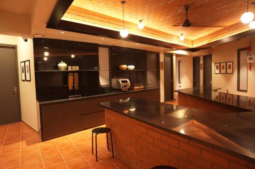 a large kitchen with a large black counter top at FLH Residences, Ambawadi in Ahmedabad