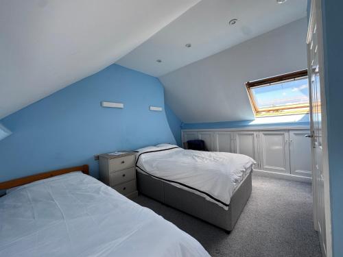a blue room with two beds and a window at Top of Family Occupied House Double Room with Free Parking in York in York