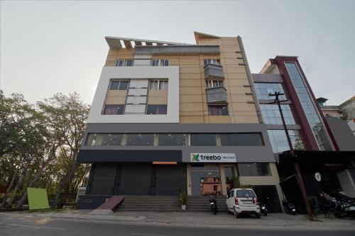 a building with a car parked in front of it at Treebo Prem Tower in Haldwāni
