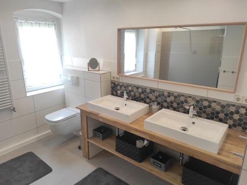 a bathroom with two sinks and a toilet at Apartment Selina in Lichtenhain