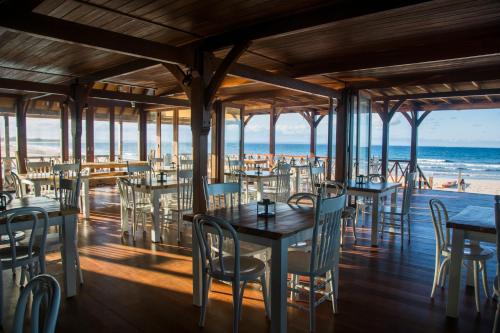 a restaurant on the beach with tables and chairs at Sentidos Beach Retreat in Miramar