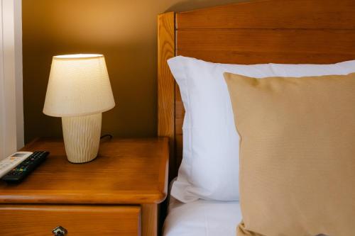a lamp on a night stand next to a bed at Hospedaria Canto do Rossio in Vidigueira