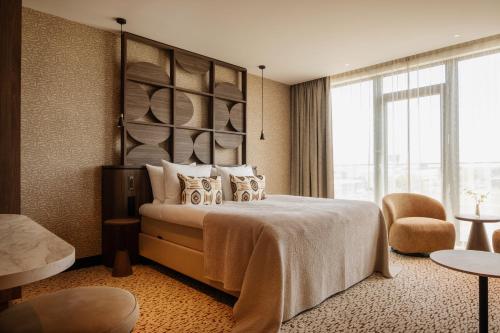 a hotel room with a bed and a large window at Van der Valk Hotel Woerden in Woerden