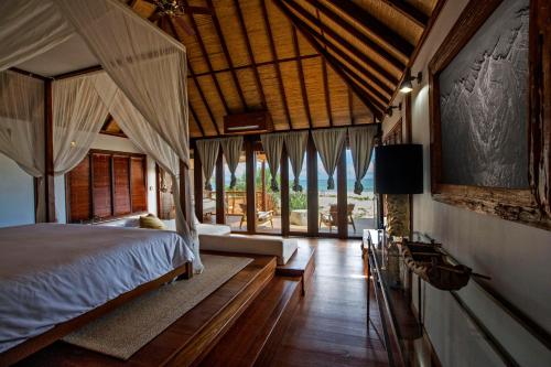 a bedroom with a bed in a room with windows at Sentidos Beach Retreat in Miramar