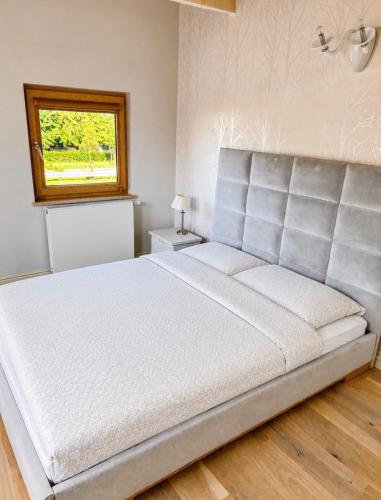 a large bed in a bedroom with a window at Willa Oliwa in Gdańsk