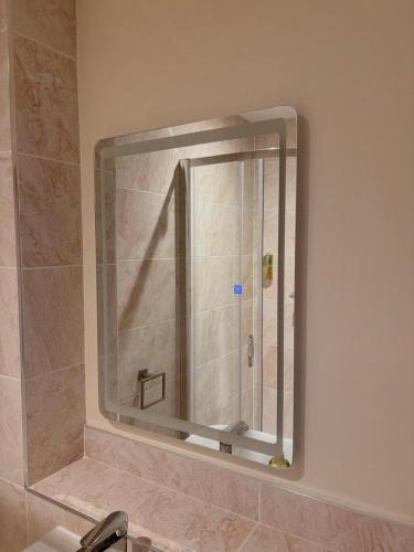 a mirror on a wall above a sink in a bathroom at ICON Hotel in Luton