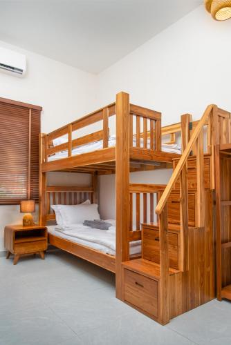 a wooden bunk bed with a ladder in a room at Turtle Tales-Tao Khon in Thai Muang