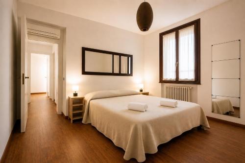 a bedroom with a bed with two towels on it at Civico 44 - vicino al Centro Storico, Ospedale e Centro Iperbarico in Ravenna