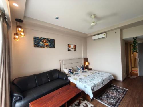 a living room with a bed and a couch at Sunlit Omaxe ITC, Greater Noida in Greater Noida