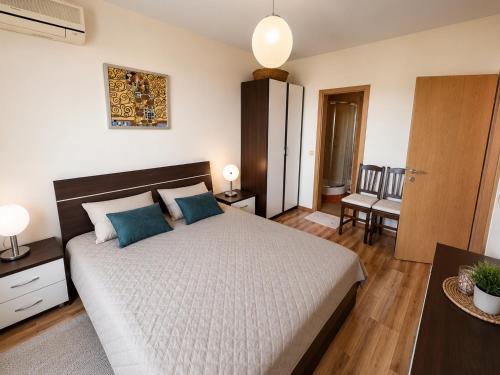 a bedroom with a large bed with blue pillows at Spacious 2 bedroom apartment in Balchik