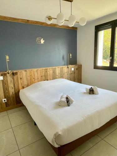 a bedroom with a large white bed with two towels at Le Balcon de Narlay in Le Frasnois